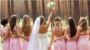 Bride and brides maids turned around looking at a forest